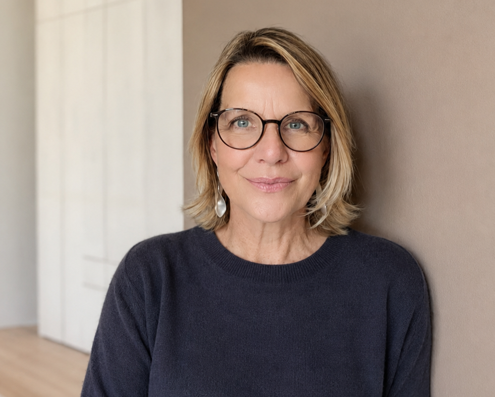 Annette Galinski lehnt in einem hellen Wohnraum an einer Wand.